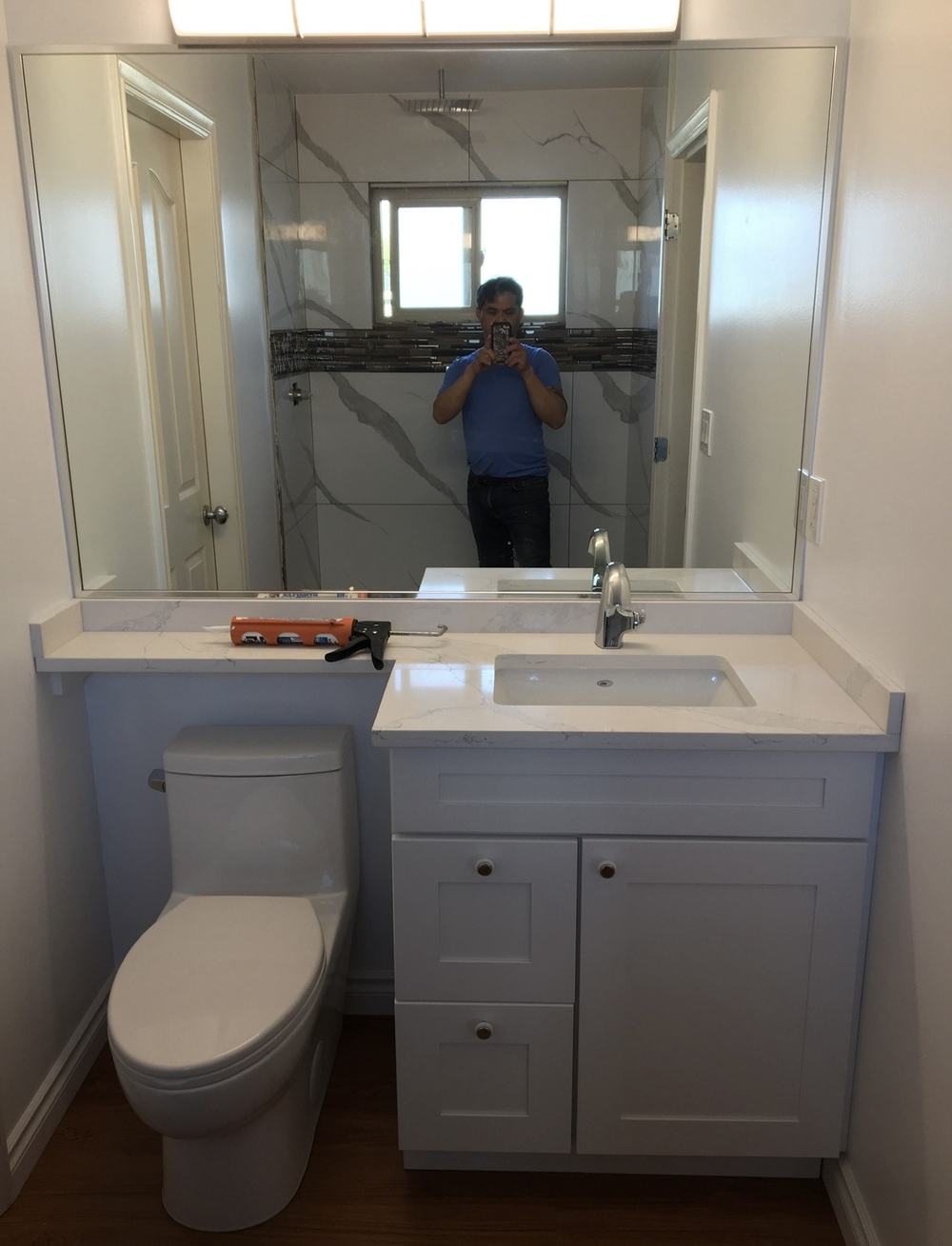 Finished bathroom with tiled shower and quartz vanity