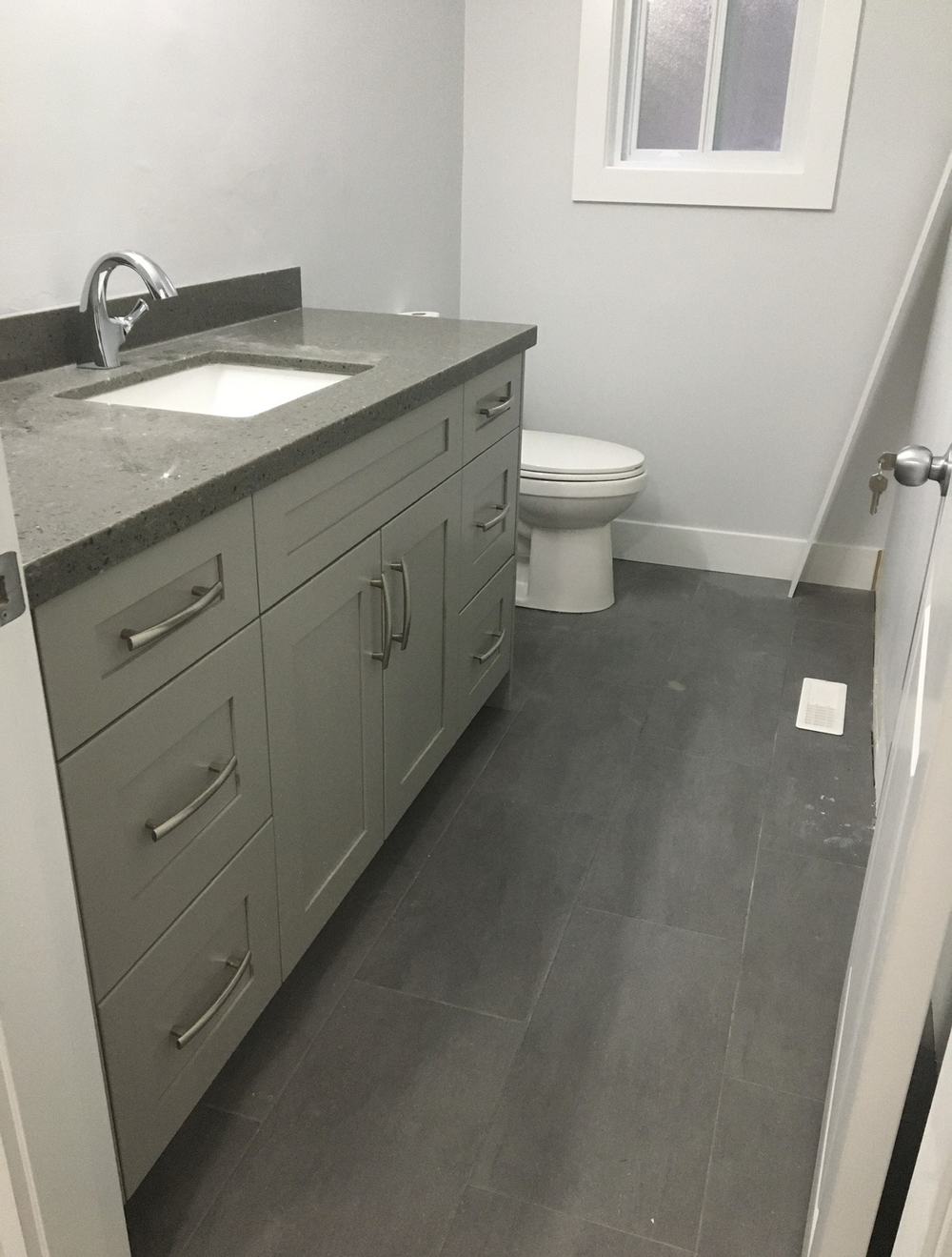 Bathroom vanity renovation with quartz counter and tile flooring