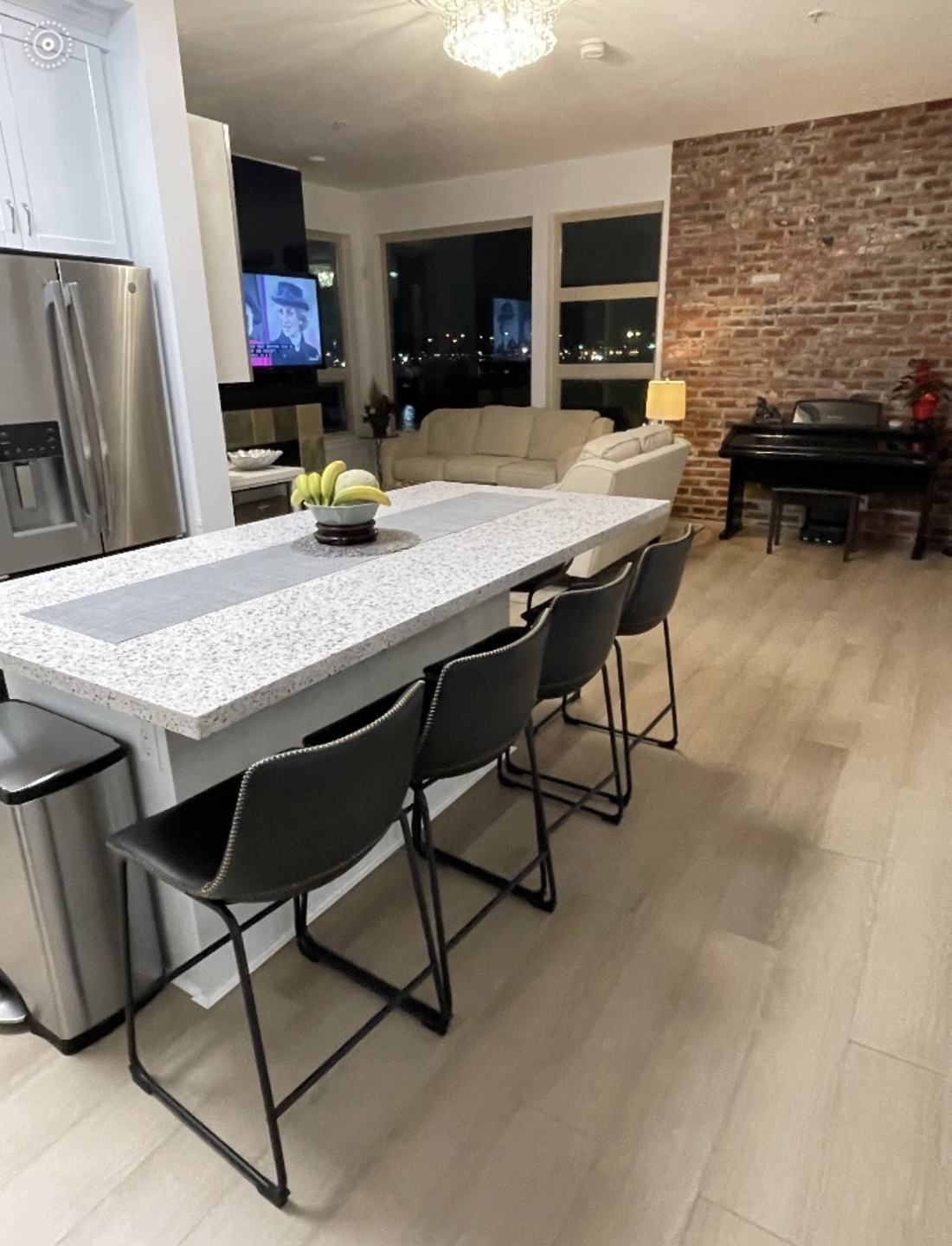 Open concept condo kitchen and living space renovation with exposed brick wall