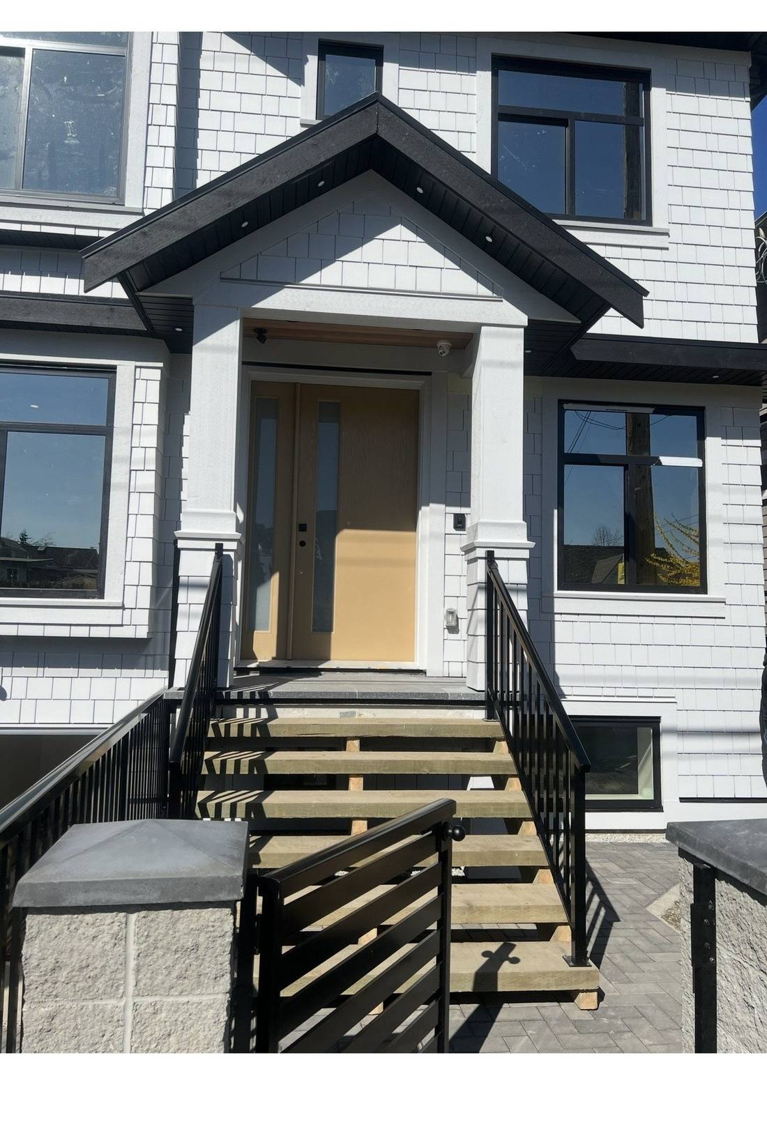 Completed Riley Park home entrance with finished shingle siding and black trim